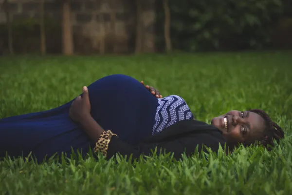 Pregnant client lying down on the grass